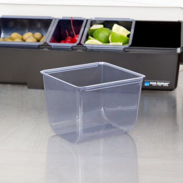 A San Jamar clear plastic container with trays of food.