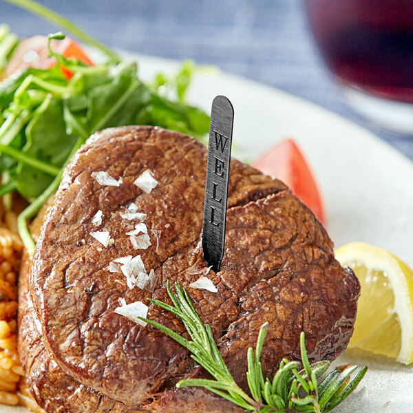 A steak with a knife and fork sticking out of it.