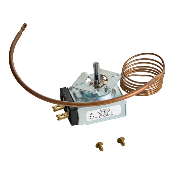 A metal thermostat component with a coiled copper tube, electrical connectors, and two small screws placed nearby.