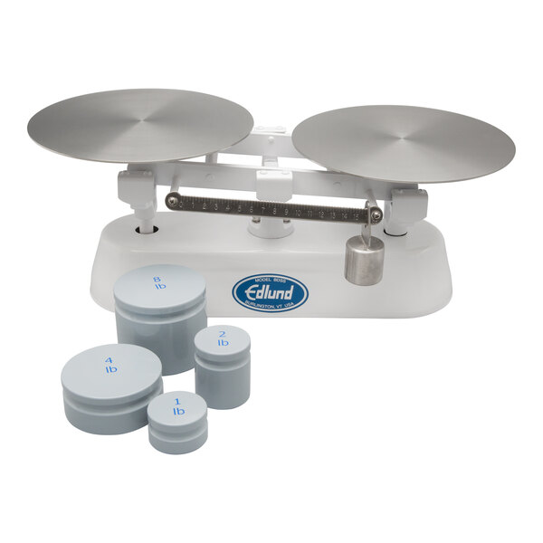 A close-up of a stainless steel Edlund baker's dough scale with round silver lids.