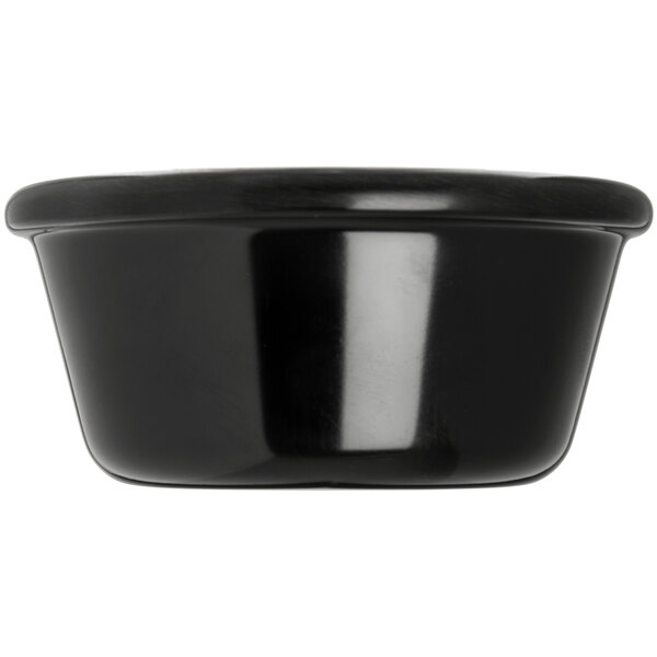 A close-up of a Carlisle black melamine ramekin.