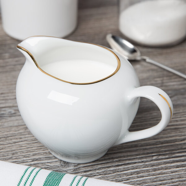 A white pitcher with a gold rim.