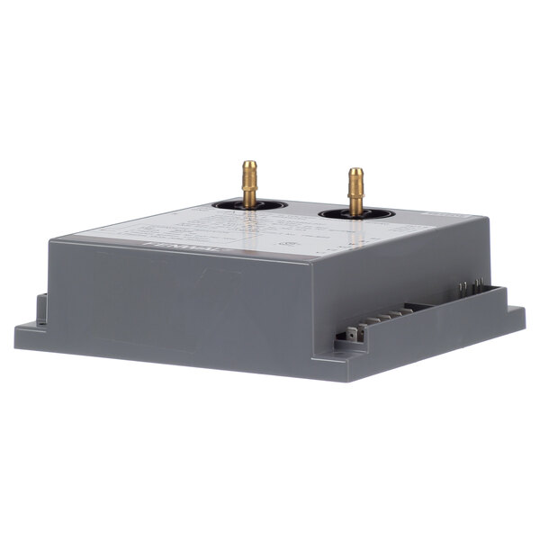 A grey Duke ignition module with gold connectors.