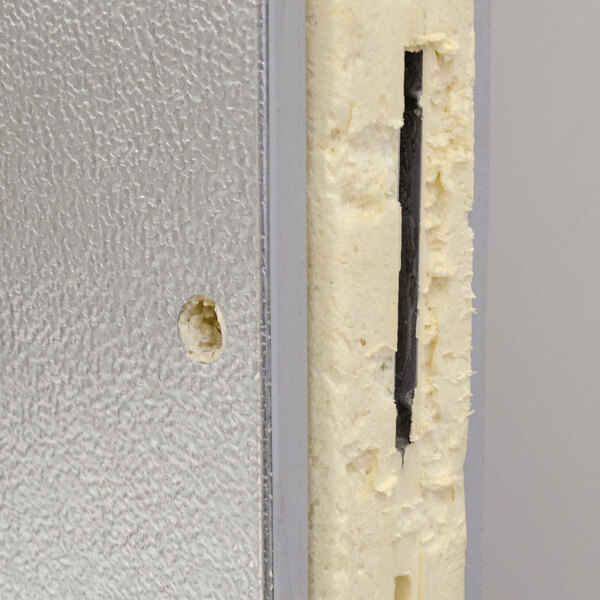 A close-up view of the cross-section of an insulated metal panel, likely from an outdoor walk-in freezer.