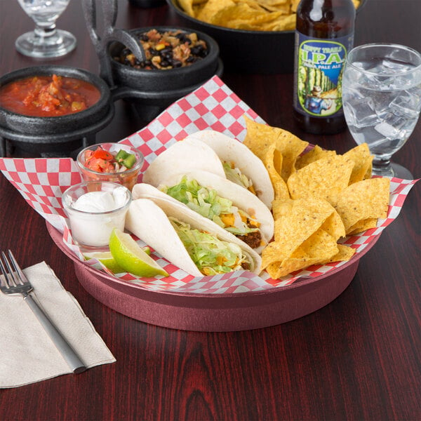 A table with a bowl of red sauce, a bowl of tacos and chips, and a Raspberry Polypropylene Deli Server filled with a white substance.