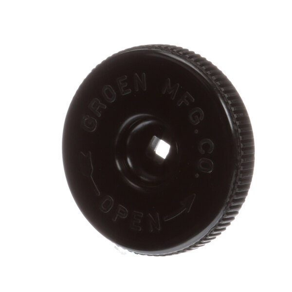 A black circular plastic handle with a hole in the middle and the word "open" on it.