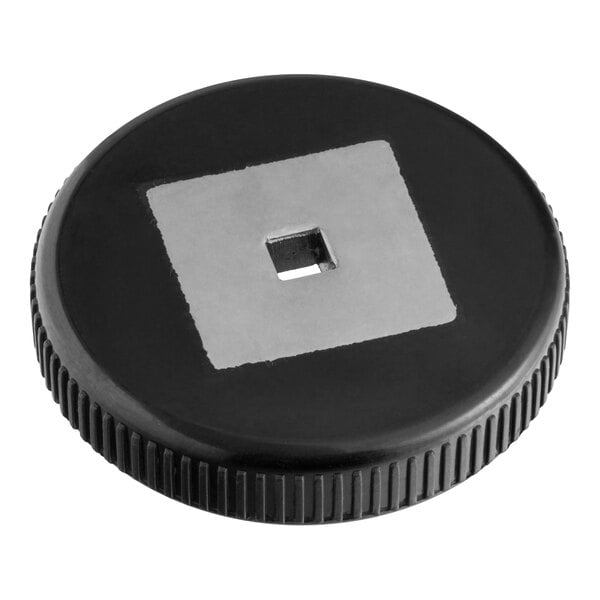 A round, black, ridged knob with a metallic square insert in the center.