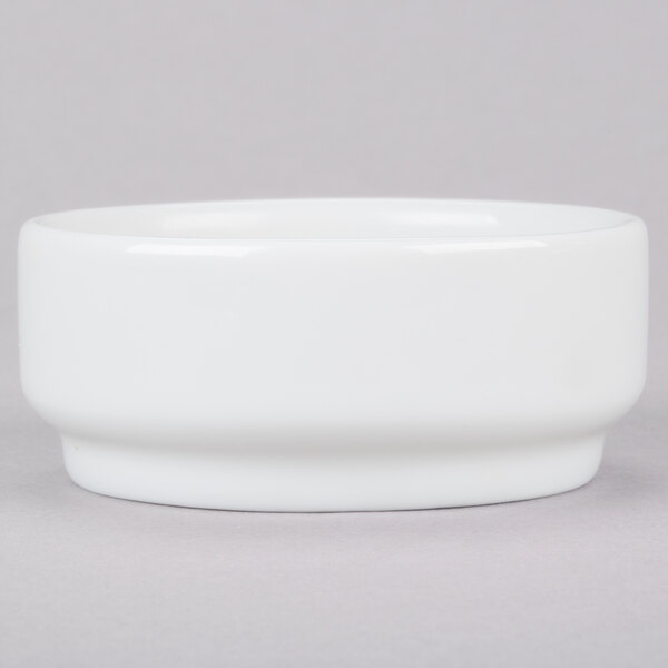 An Arcoroc white porcelain bowl on a gray surface.