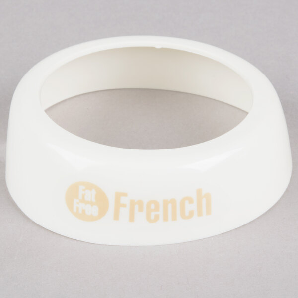 A white plastic circular Tablecraft salad dressing dispenser collar with beige lettering reading "Fat Free French"