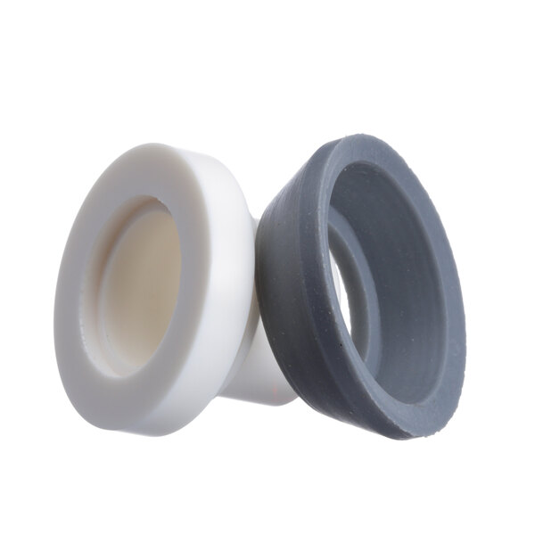 A close-up of a pair of white and grey rubber plugs with a grey ring.