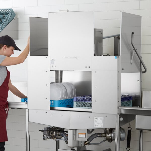 A commercial double rack low temperature dishwasher with stainless steel construction, shown in use with dish racks inside.
