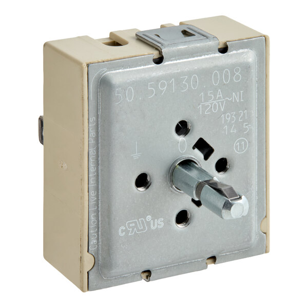 A square electrical switch component with a metal faceplate, a central rotating shaft, and various markings and holes on the front.