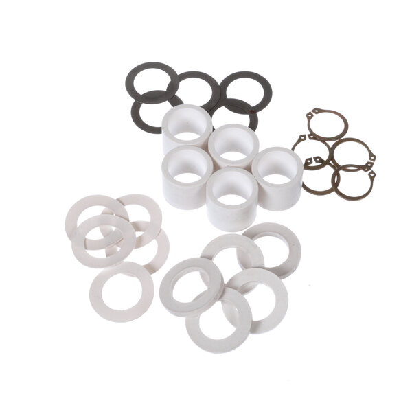 A group of white cylindrical washers and metal rings.