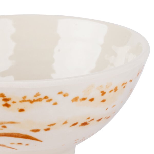 A close-up of a white Thunder Group Gold Orchid melamine rice bowl with brown spots.