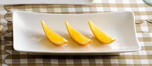 A CAC Super White rectangular porcelain platter with sliced oranges on it.