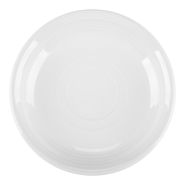 A close-up of a white Tuxton Concentrix saucer with a circular pattern on it.