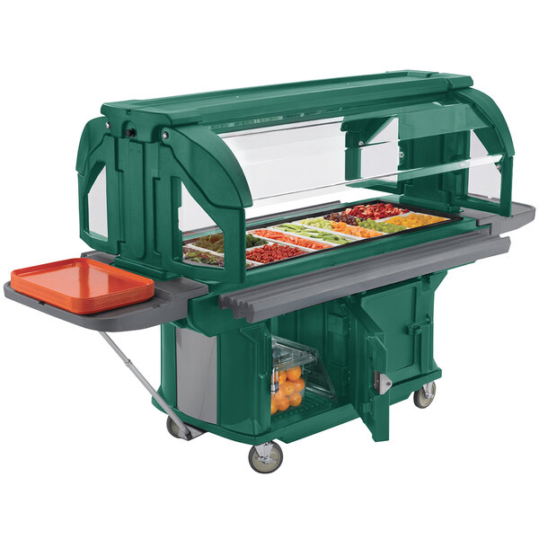 A Kentucky Green Cambro Versa food bar on a table in an outdoor catering setup.