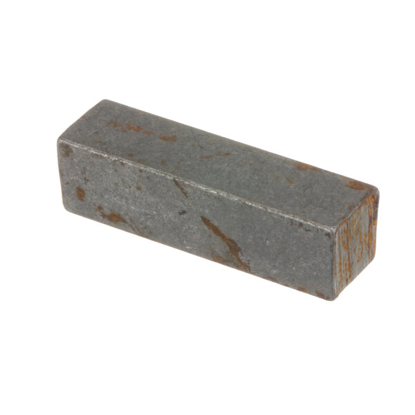 A rectangular metal Groen Z001474 key with a grey surface and rust stains.