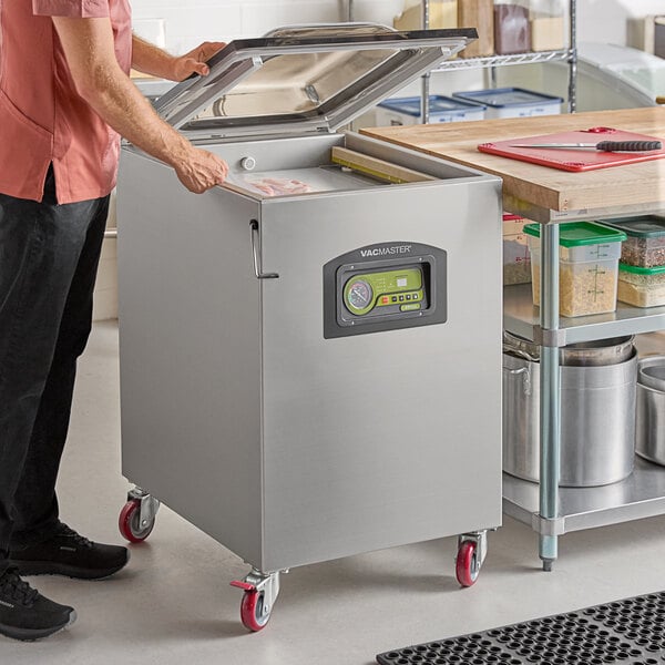 A stainless steel floor model chamber vacuum packaging machine with a digital control panel and two seal bars.