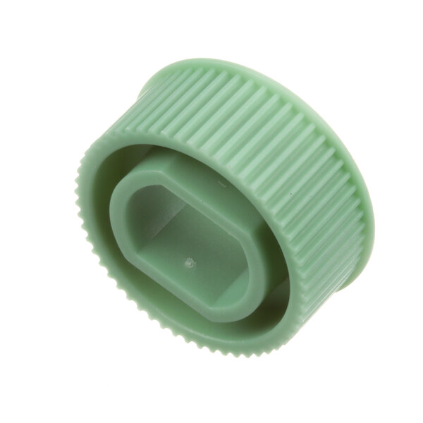 A close-up of a green plastic Franke large gear wheel with a square hole.