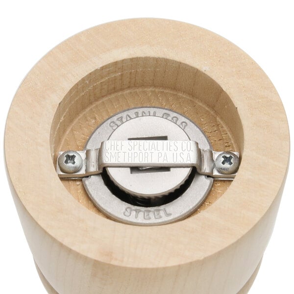 A wooden cylinder with a metal grinder inside.