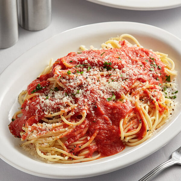 A plate of spaghetti with Furmano's home style spaghetti sauce and parmesan cheese with a fork.