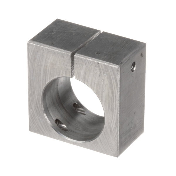 A close-up of a square metal block with a hole in it.