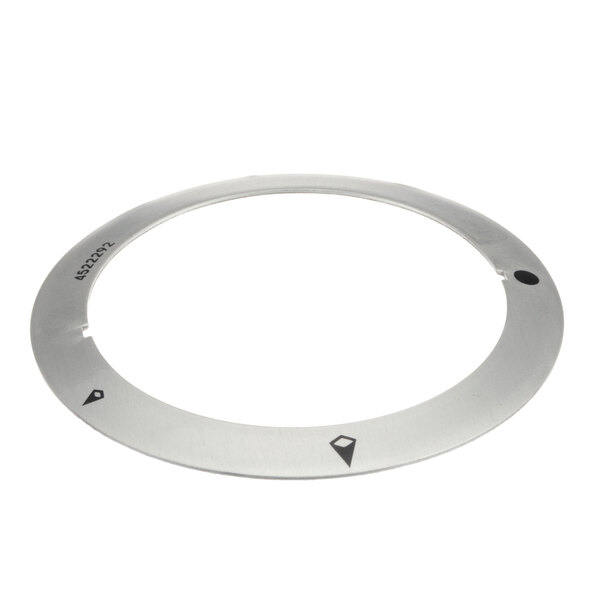A circular metal plate with a black dot on a Garland griddle.
