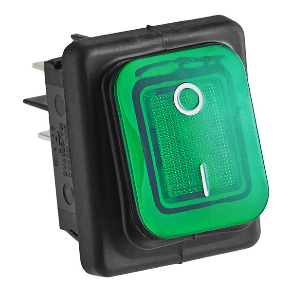 A green push button switch with a black square on a black device.