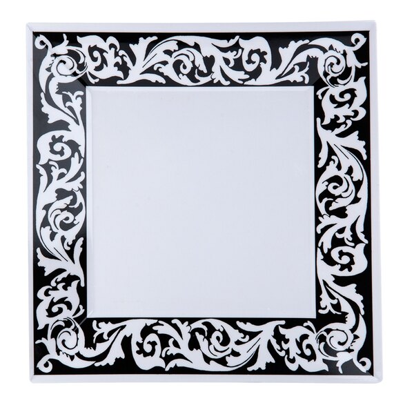 A close up of a black and white square plate with a decorative design.