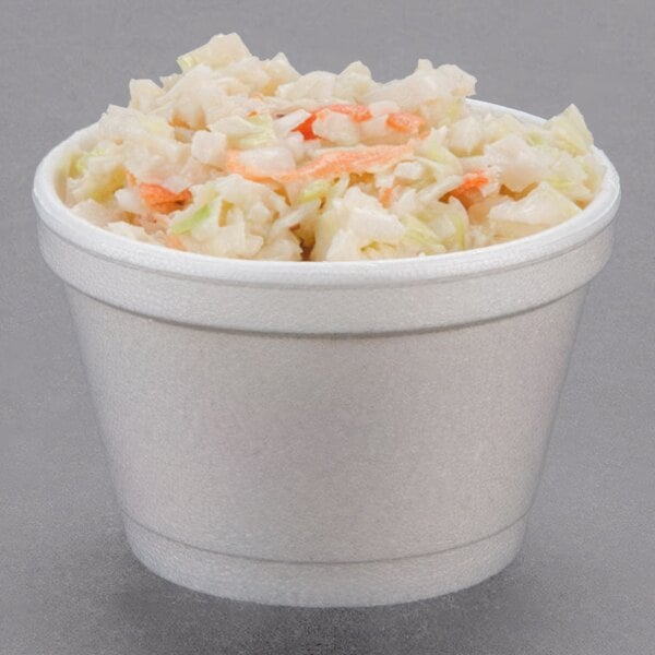 A white Dart foam food container filled with coleslaw.