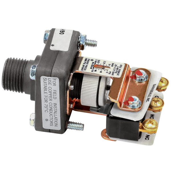 A close-up of a Crown Steam pressure switch with a wire attached.