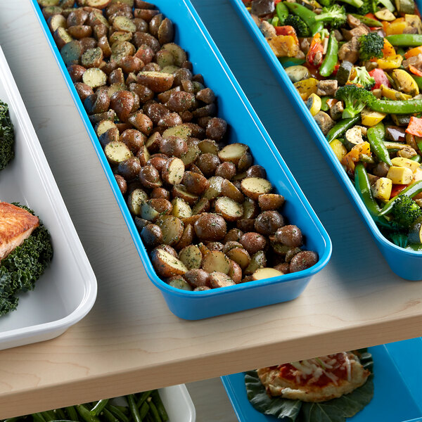 A blue tray of food with potatoes and vegetables on a table.