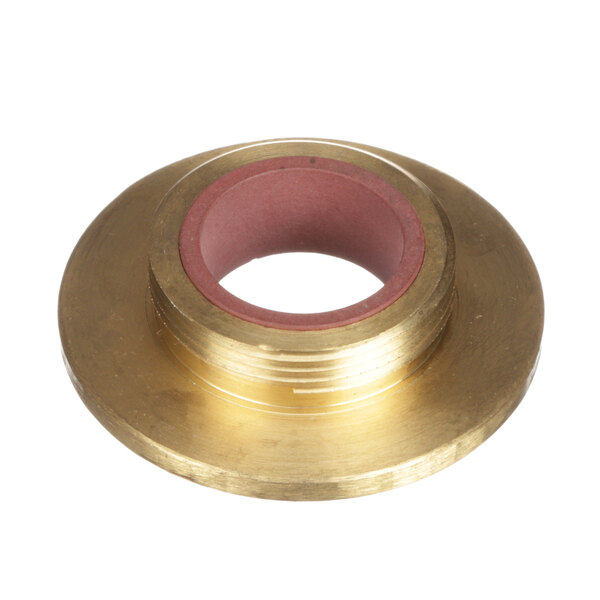 A brass plated circular object with a red tape.