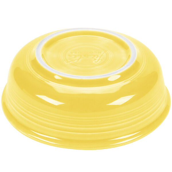 A yellow Fiesta china bowl with a white rim filled with yellow liquid.