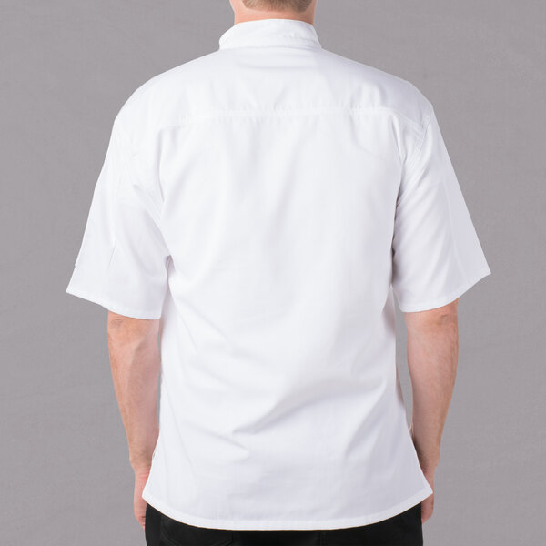 A man wearing a white Mercer Culinary chef jacket with short sleeves.