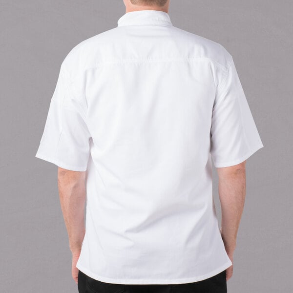 A man wearing a white Mercer Culinary chef jacket with short sleeves.