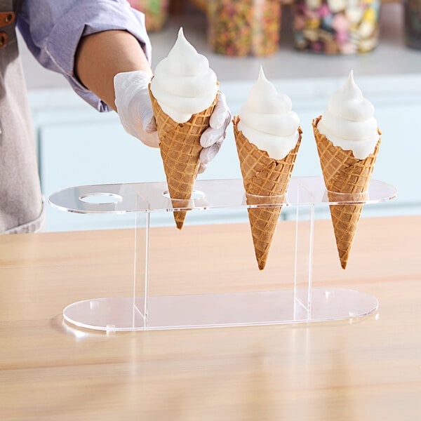 A person holding a Choice 4 Hole Acrylic Cone Holder with ice cream cones.