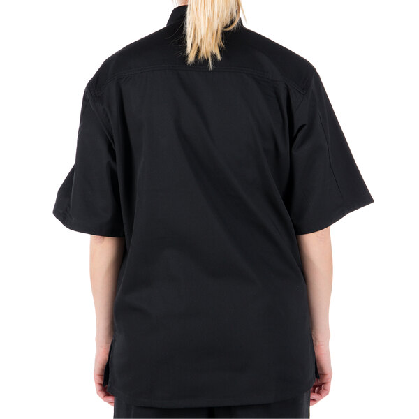 A woman wearing a black Mercer Culinary chef jacket.