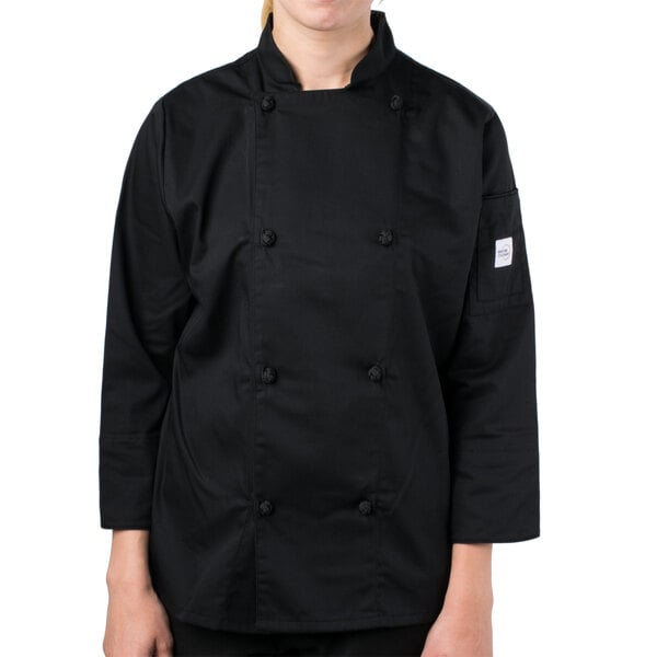 A young woman wearing a Mercer Culinary black chef coat with cloth knot buttons.