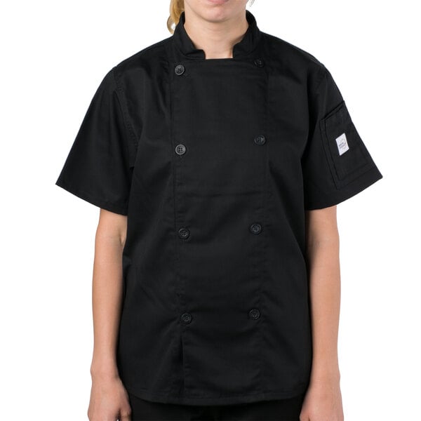 A woman wearing a Mercer Culinary black chef coat.