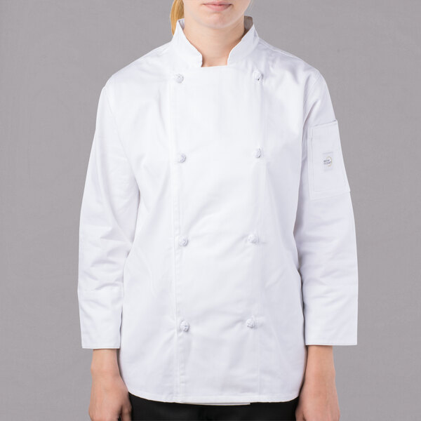 A woman wearing a white Mercer Culinary long sleeve chef jacket.