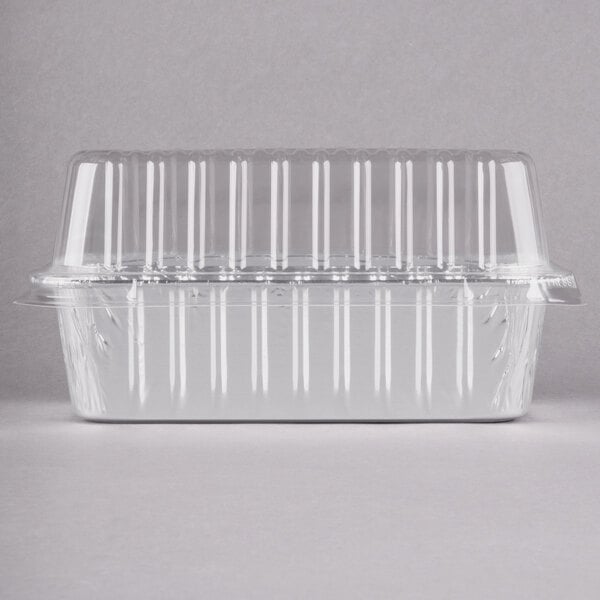 A clear plastic container with a clear dome lid filled with foil bread loaf pans.