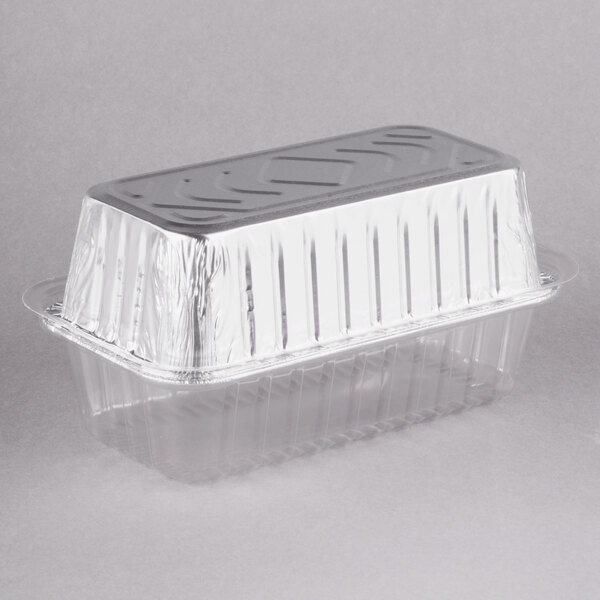 A clear plastic container with a clear dome lid on a Durable Packaging foil bread loaf pan.