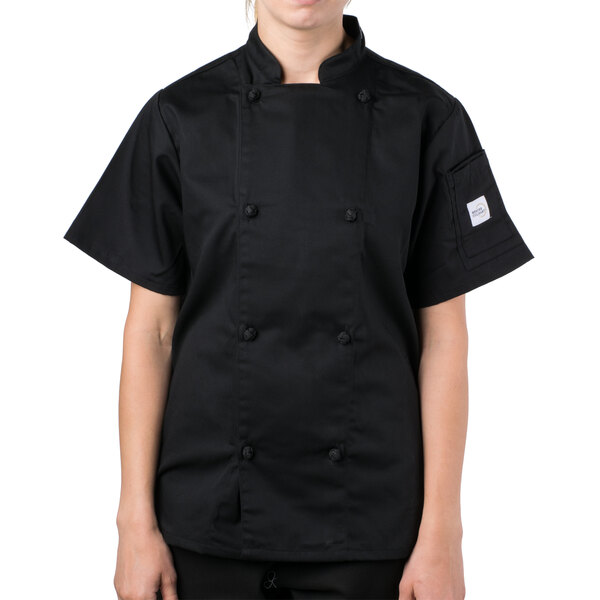 A woman wearing a Mercer Culinary black chef coat.