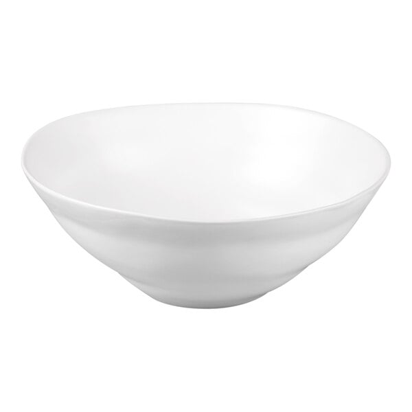 A large white stoneware serving bowl with a matte finish and a wavy rim.