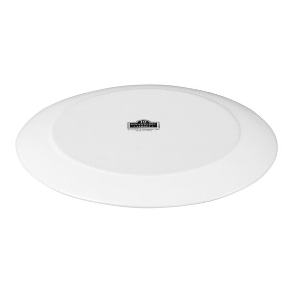 A white stoneware dinner plate with a matte finish and a subtle wave design.