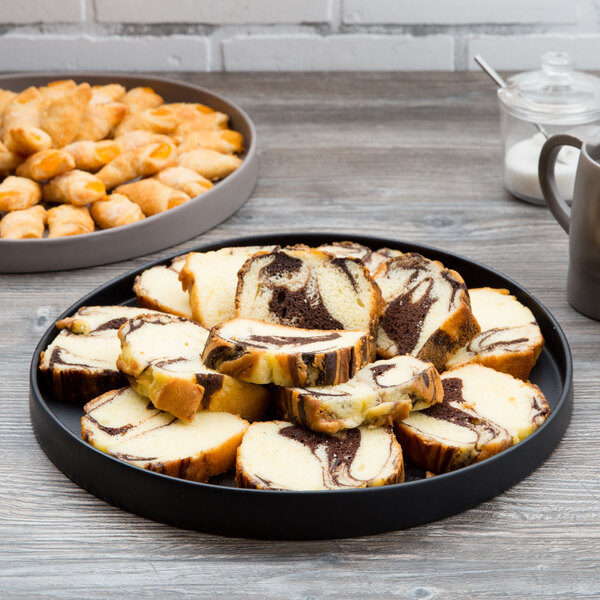 A 10 Strawberry Street black stoneware tray with food on a table.