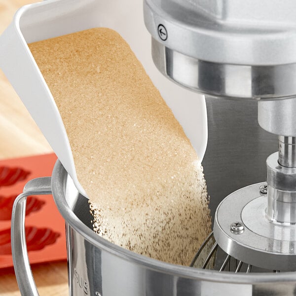 A machine pouring Golden Barrel Cane Sugar into a container.