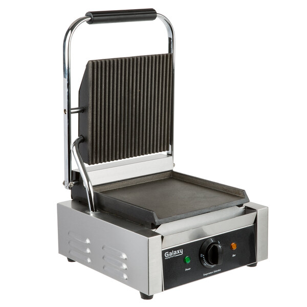 A Galaxy stainless steel Panini grill with grooved and smooth griddle plates on top.